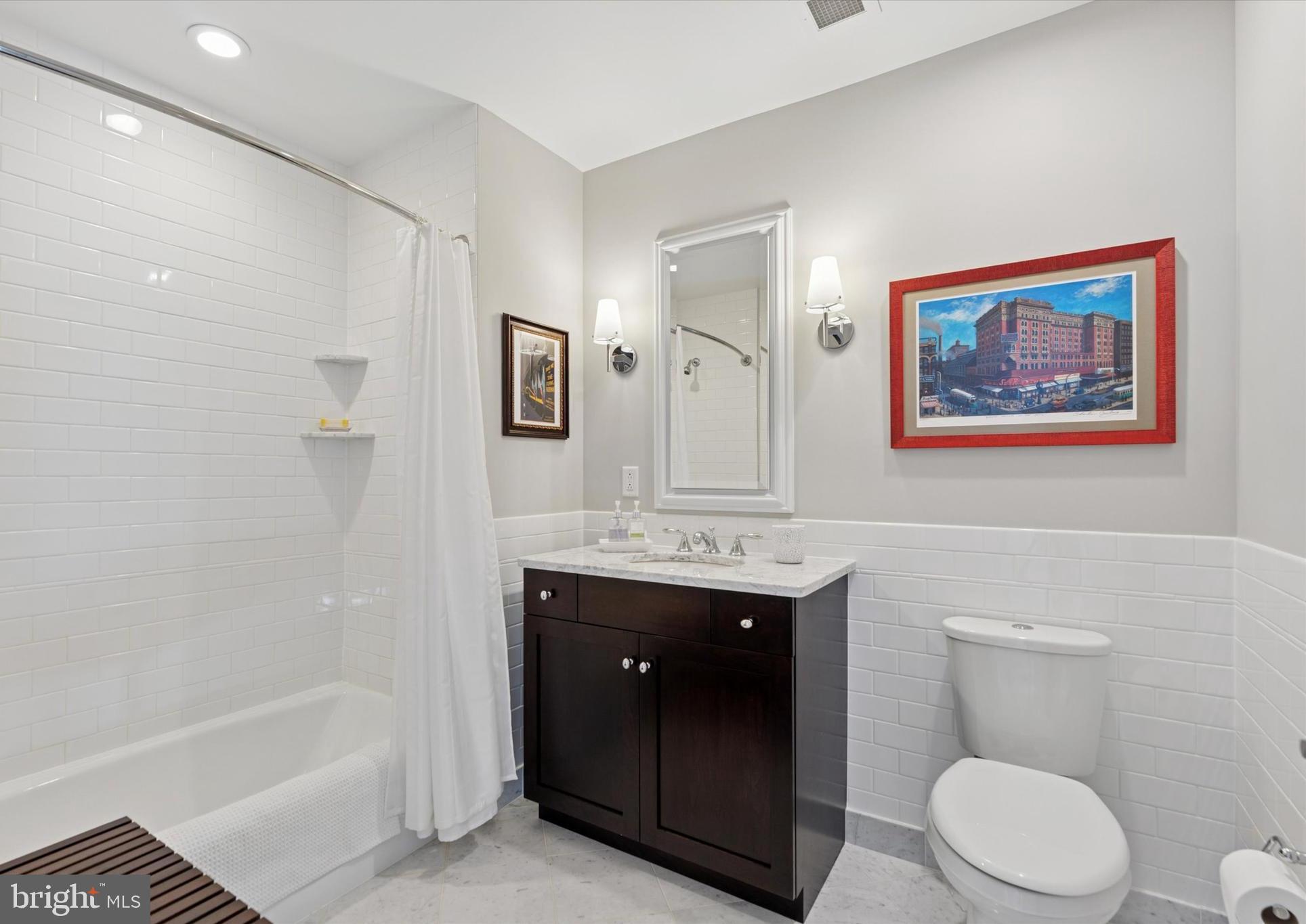 125 Iron Works Way Wayne, PA 19087 - Photo 27 of 32 a bathroom with a toilet a sink a mirror a bathtub and vanity
