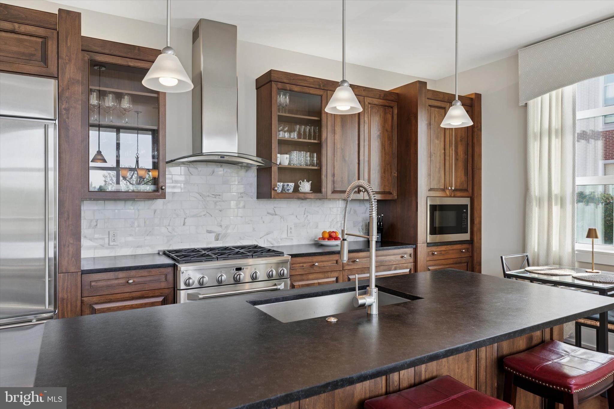 125 Iron Works Way Wayne, PA 19087 - Photo 10 of 32 a kitchen with stainless steel appliances granite countertop a sink a stove and a wooden cabinets