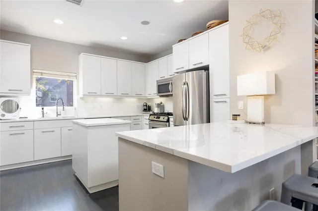 a kitchen with refrigerator cabinets and a sink