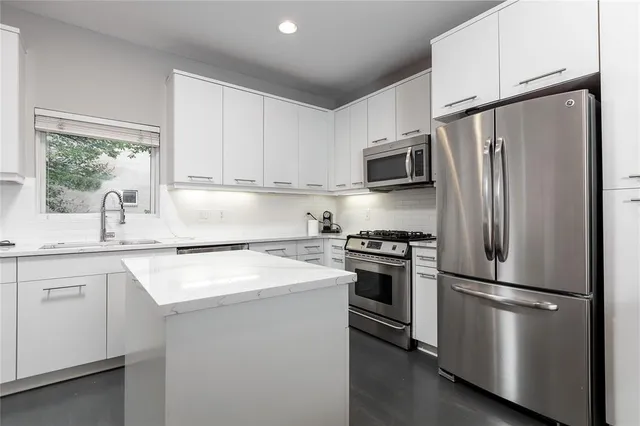 a kitchen with stainless steel appliances a refrigerator sink and microwave