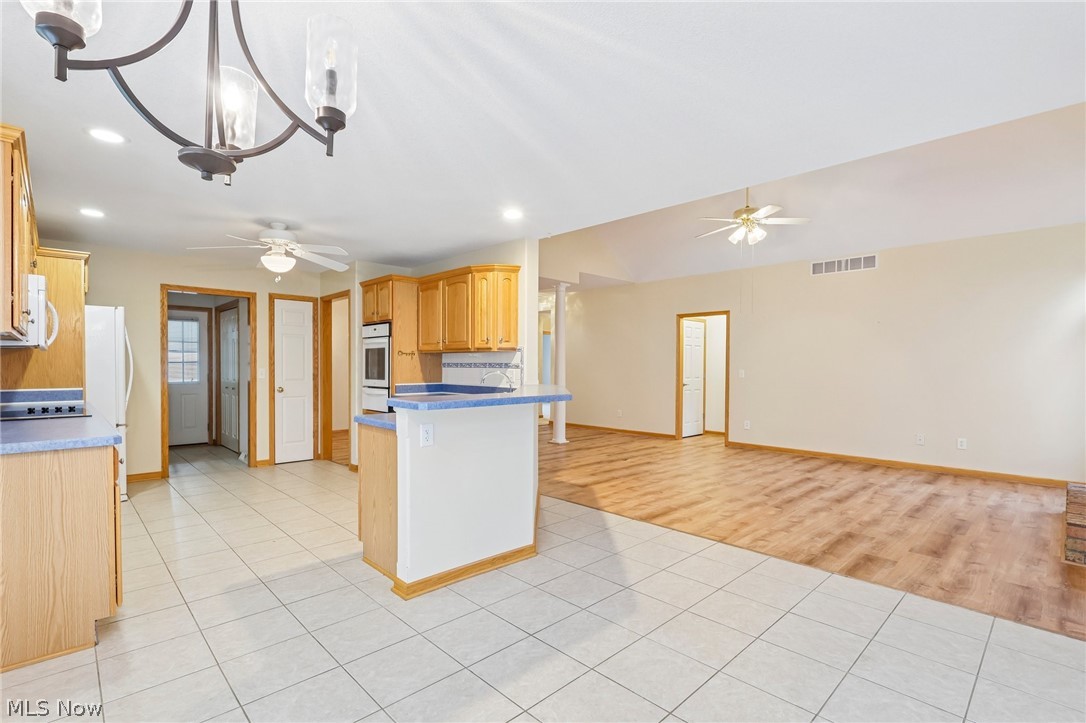 7007 Clingan Road, Unit 85 Youngstown, OH 44514 - Photo 15 of 46 Kitchen with tile flooring and wood cabinetry, featuring a built-in oven and a breakfast bar