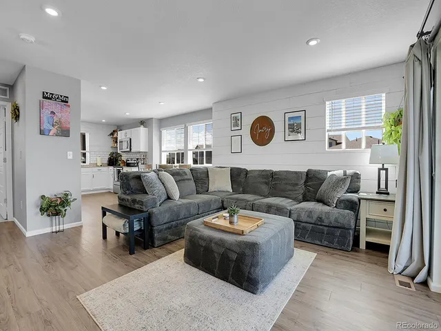 a living room with furniture kitchen view and a window