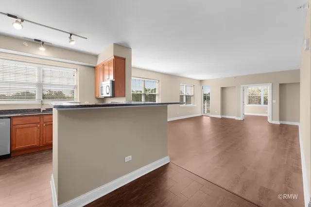 a kitchen with stainless steel appliances a sink a stove cabinets and wooden floor