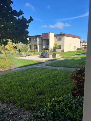 a front view of a house with a garden and a tree
