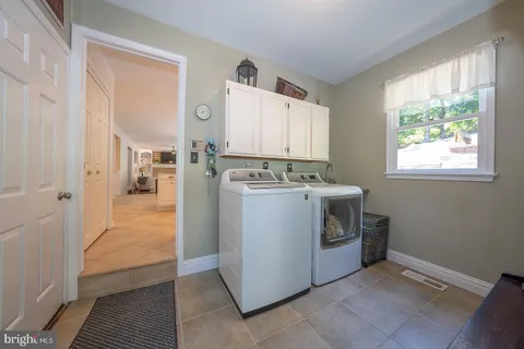 a utility room with cabinets dryer and washer