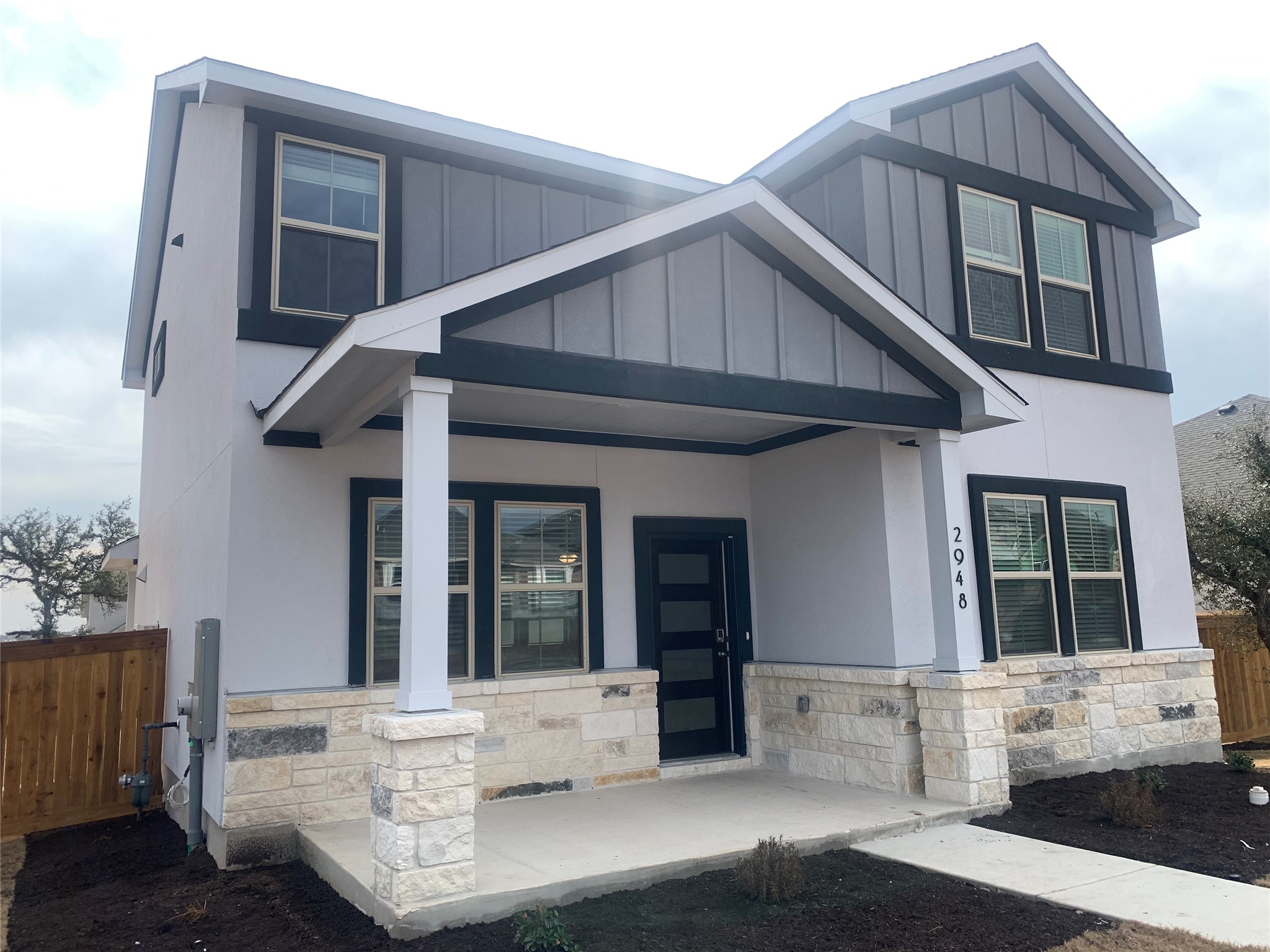 2948 Sage Ranch Drive Leander, TX 78641 - Photo 2 of 28 A striking contemporary residence boasts a welcoming covered front porch, framed by a blend of stone and siding.