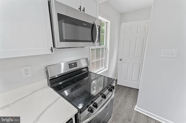 a kitchen with a refrigerator sink and cabinets