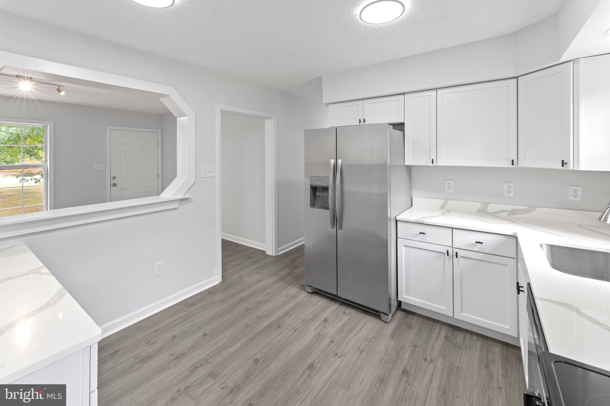 1543 Vawter Corner Road Louisa, VA 23093 - Photo 25 of 43 a kitchen with a refrigerator sink and cabinets