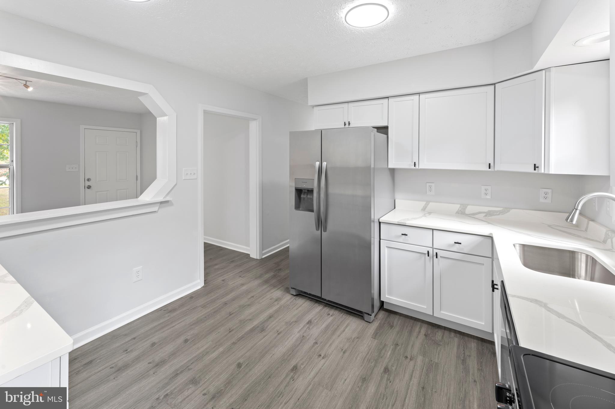 1543 Vawter Corner Road Louisa, VA 23093 - Photo 26 of 43 a kitchen with a refrigerator sink and cabinets