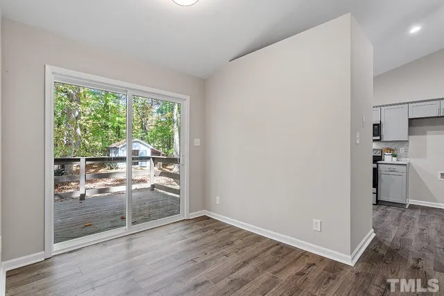 a view of a kitchen with wooden floor and a refrigerator