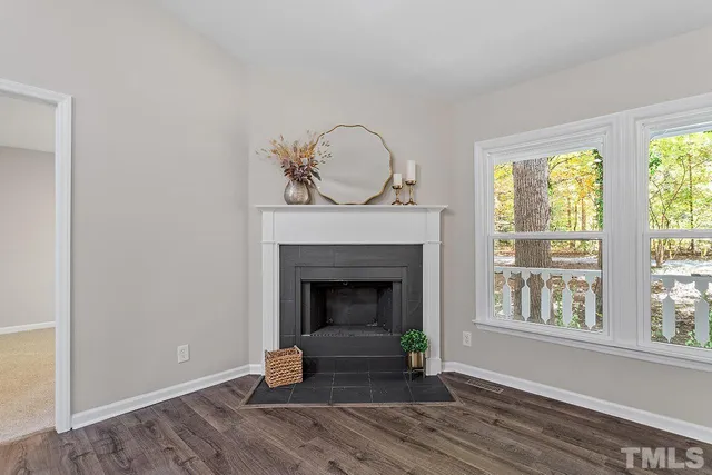 a living room with fireplace and a wooden floor