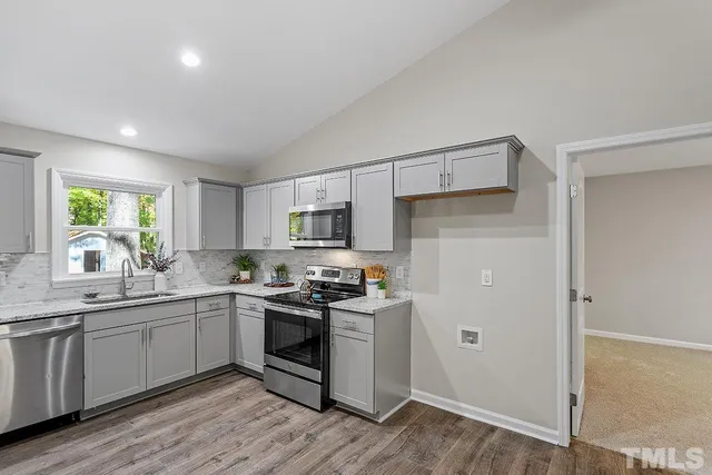 a kitchen with stainless steel appliances a sink stove and cabinets
