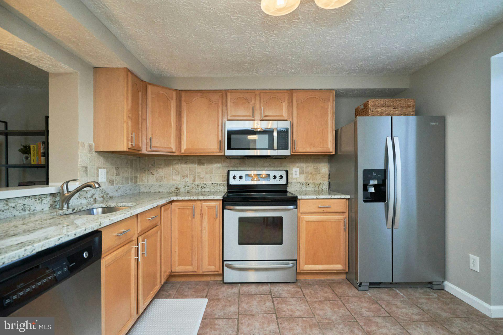 1750 Sundance Drive Reston, VA 20194 - Photo 11 of 36 a kitchen with stainless steel appliances granite countertop a stove a refrigerator and a sink