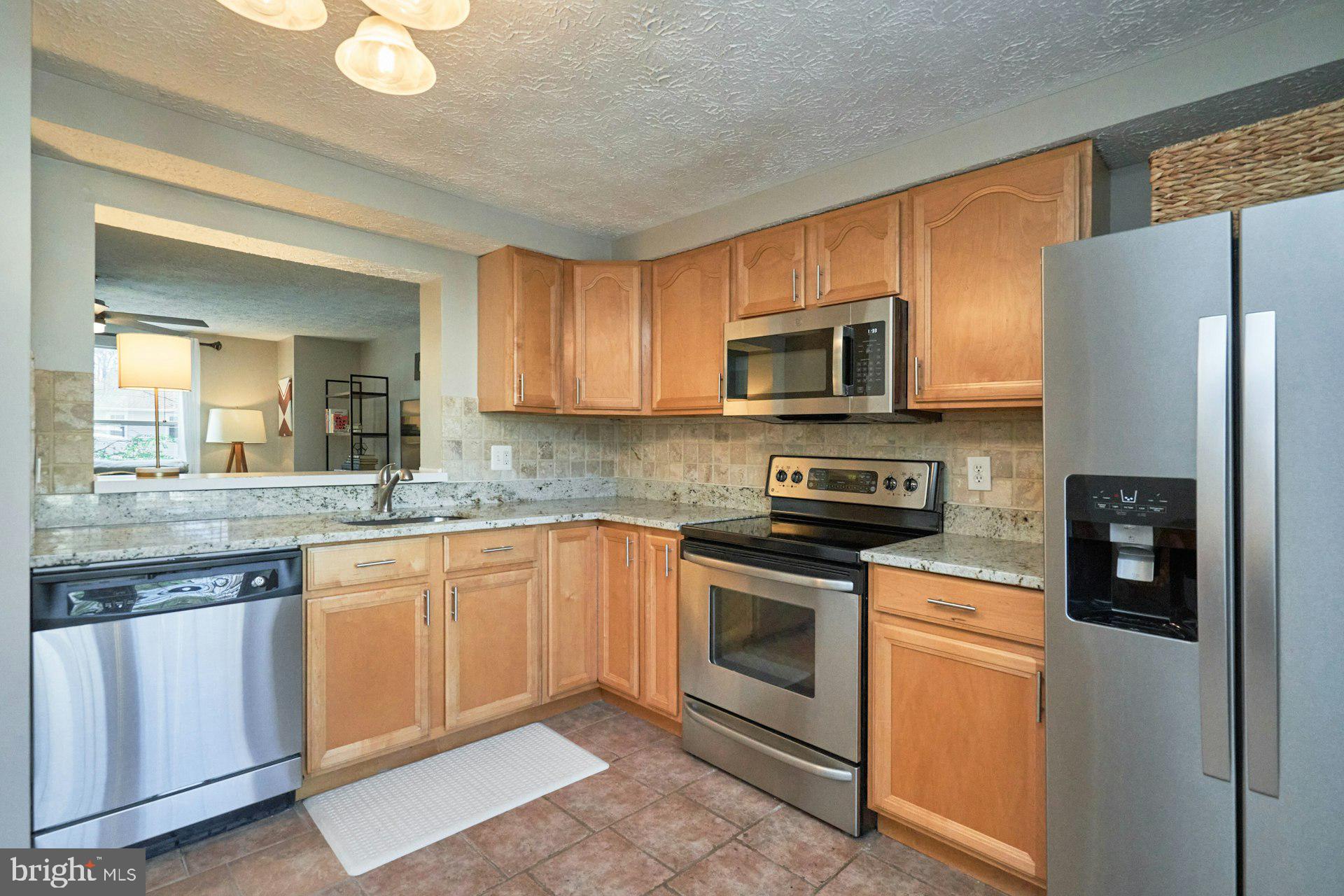 1750 Sundance Drive Reston, VA 20194 - Photo 12 of 36 a kitchen with granite countertop a refrigerator stove and microwave
