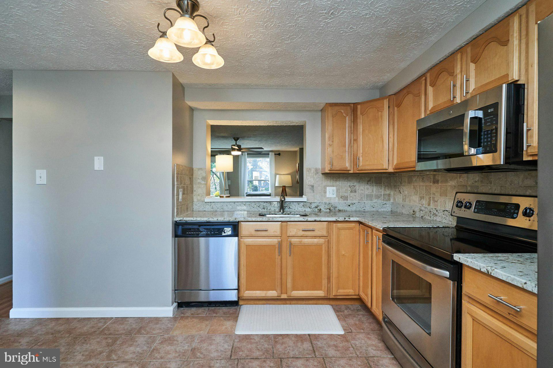 1750 Sundance Drive Reston, VA 20194 - Photo 13 of 36 a kitchen with stainless steel appliances granite countertop a sink and dishwasher a stove top oven with wooden floor