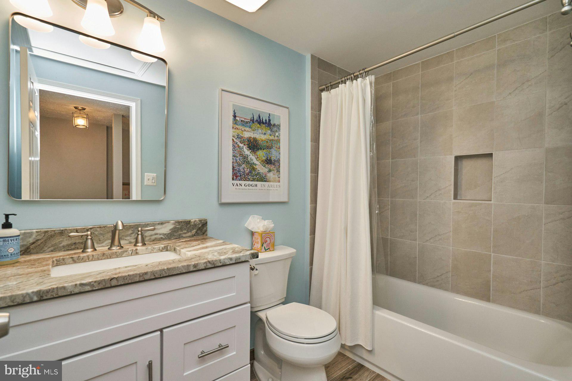 1750 Sundance Drive Reston, VA 20194 - Photo 23 of 36 a bathroom with a granite countertop sink a toilet a mirror a vanity and shower