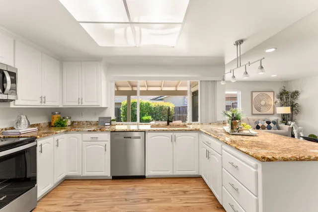 a kitchen with a sink window and cabinets