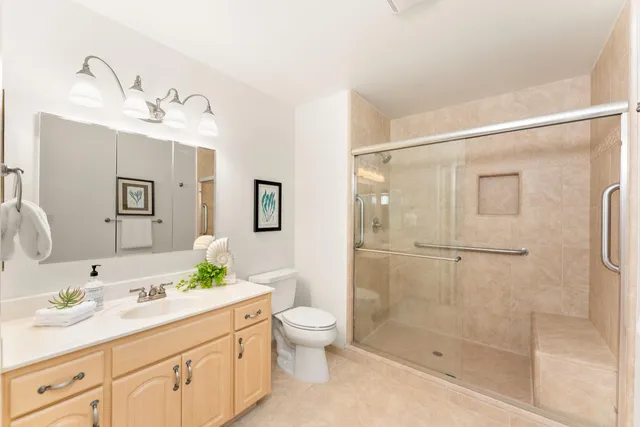 a bathroom with a granite countertop sink a toilet and shower