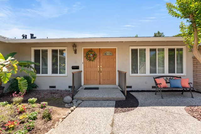 a view of a house with backyard sitting area and garden