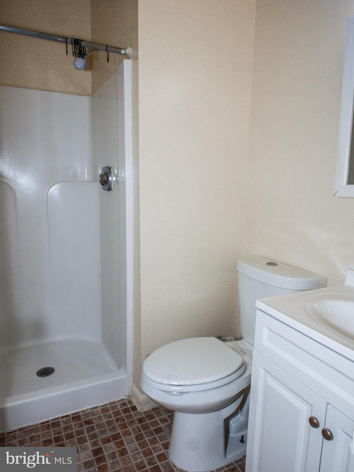 6661 Spring Mill Circle Baltimore, MD 21207 - Photo 10 of 22 a bathroom with a shower a toilet and a sink