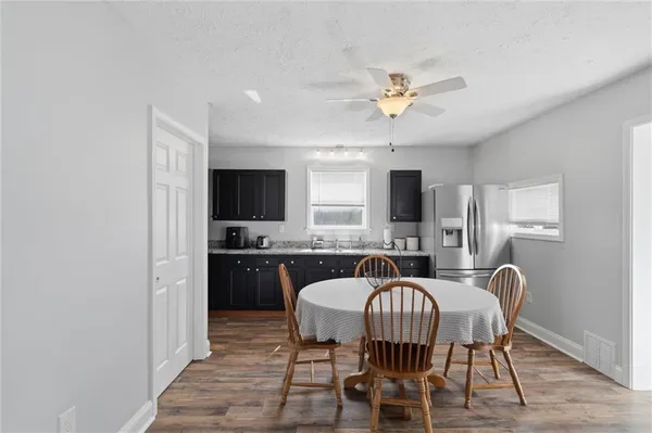 a kitchen with a table chairs refrigerator and a sink
