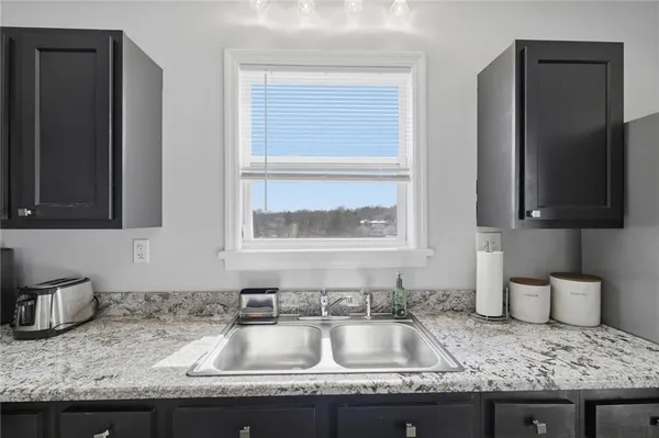 a kitchen with granite countertop a sink and a window