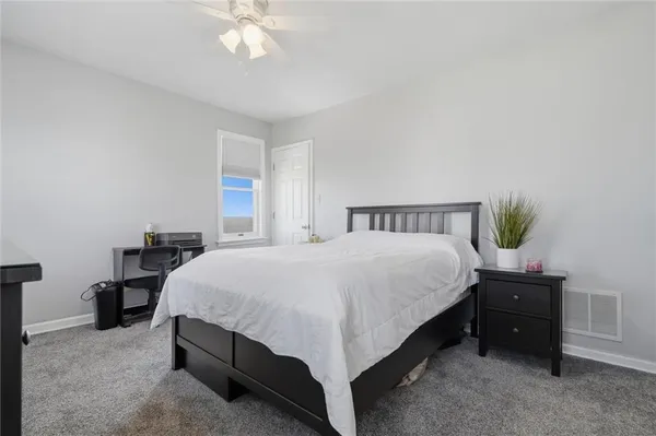 a spacious bedroom with a bed and a chandelier