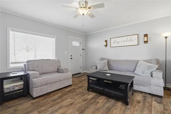 a living room with furniture and a wooden floor
