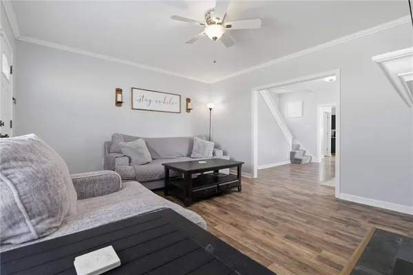 a living room with furniture and a wooden floor