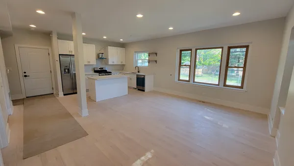 a large kitchen with a large window and stainless steel appliances