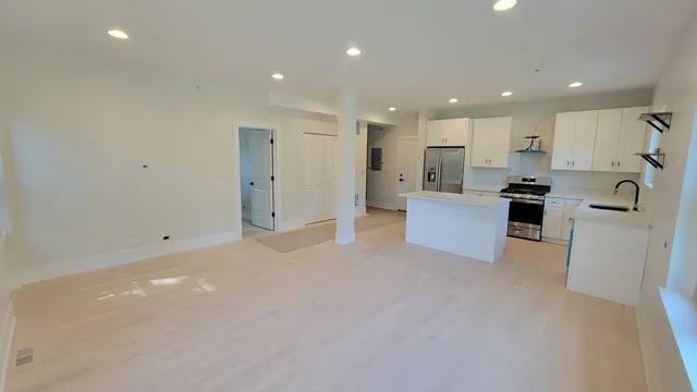 a view of a kitchen with a sink and dishwasher a refrigerator with white cabinets