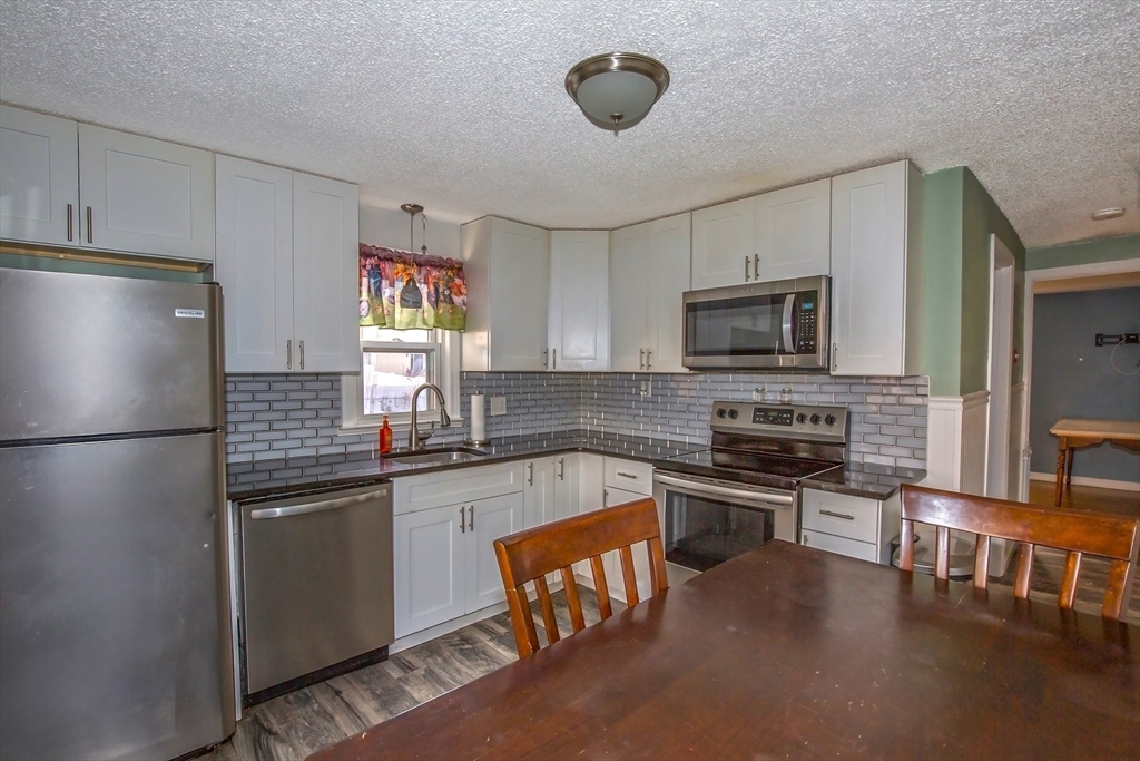 65 Garland Street Springfield, MA 01118 - Photo 12 of 39 a kitchen with stainless steel appliances granite countertop a refrigerator stove microwave and sink