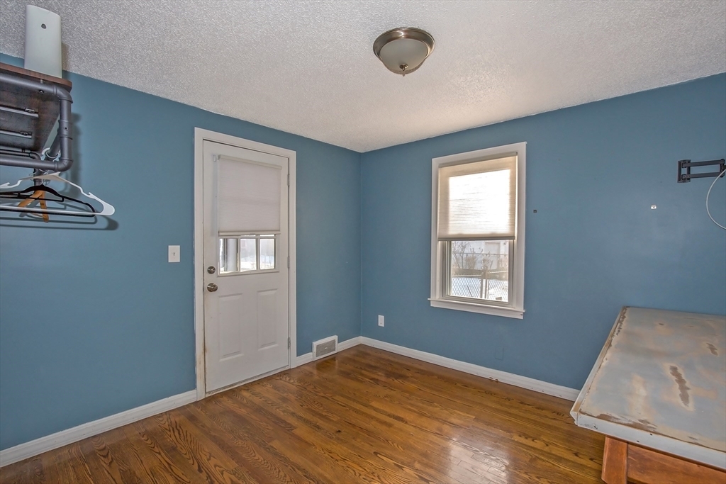 65 Garland Street Springfield, MA 01118 - Photo 15 of 39 a view of an empty room with window and wooden floor