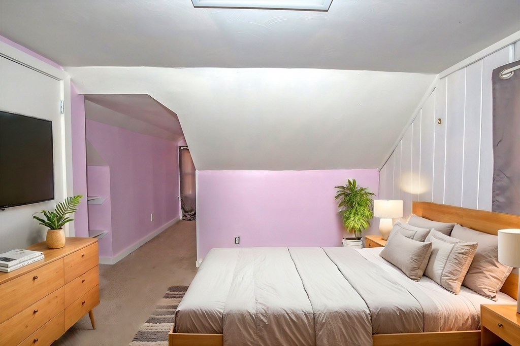 65 Garland Street Springfield, MA 01118 - Photo 32 of 39 a bedroom with a bed potted plant on dresser and a wooden floor