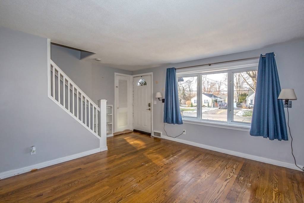 65 Garland Street Springfield, MA 01118 - Photo 4 of 39 a view of an empty room with wooden floor and a window