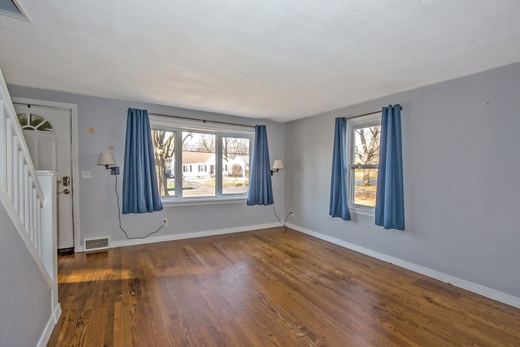 65 Garland Street Springfield, MA 01118 - Photo 7 of 39 an empty room with wooden floor and windows