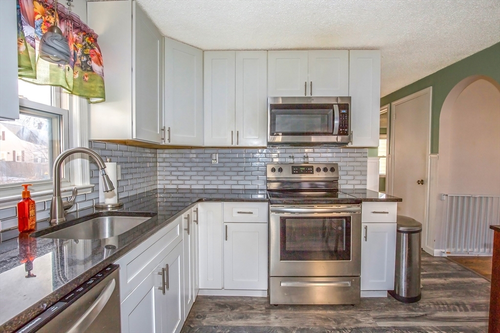 65 Garland Street Springfield, MA 01118 - Photo 9 of 39 a kitchen with stainless steel appliances granite countertop a stove and a sink