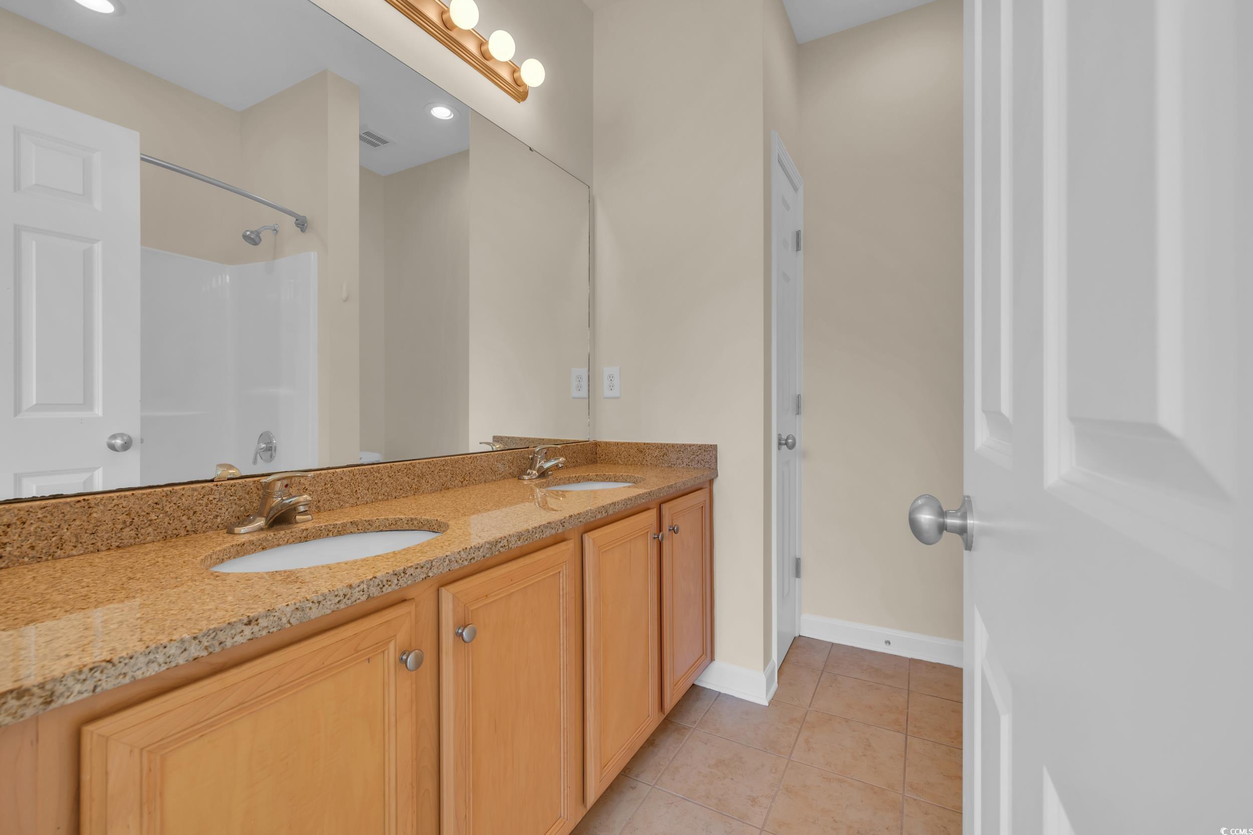945 Rosencrans Lane, Unit B Myrtle Beach, SC 29577 - Photo 16 of 32 Full bathroom featuring double vanity, tile patterned flooring, and a shower