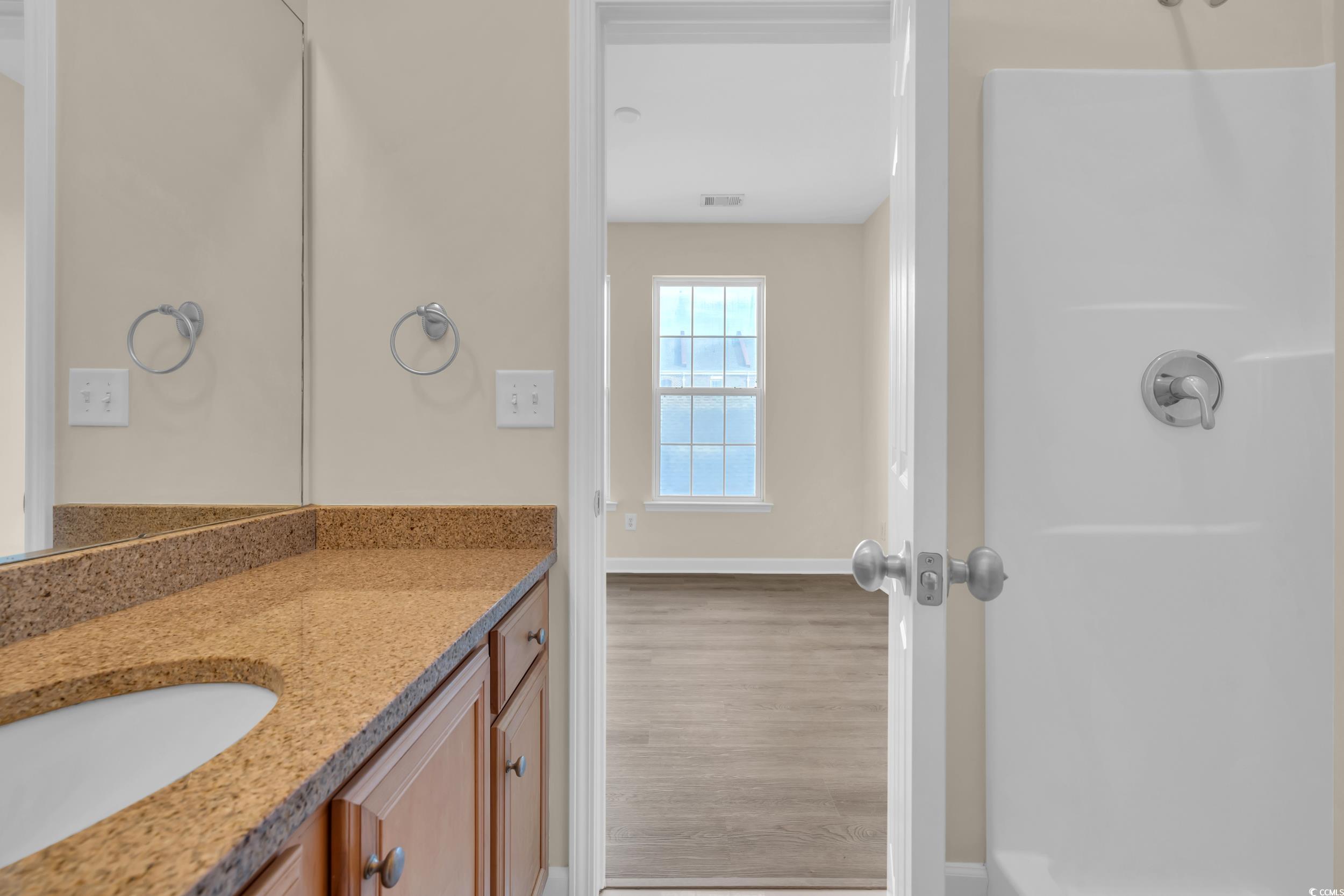 945 Rosencrans Lane, Unit B Myrtle Beach, SC 29577 - Photo 21 of 32 Full bathroom with vanity, wood finished floors, and a shower