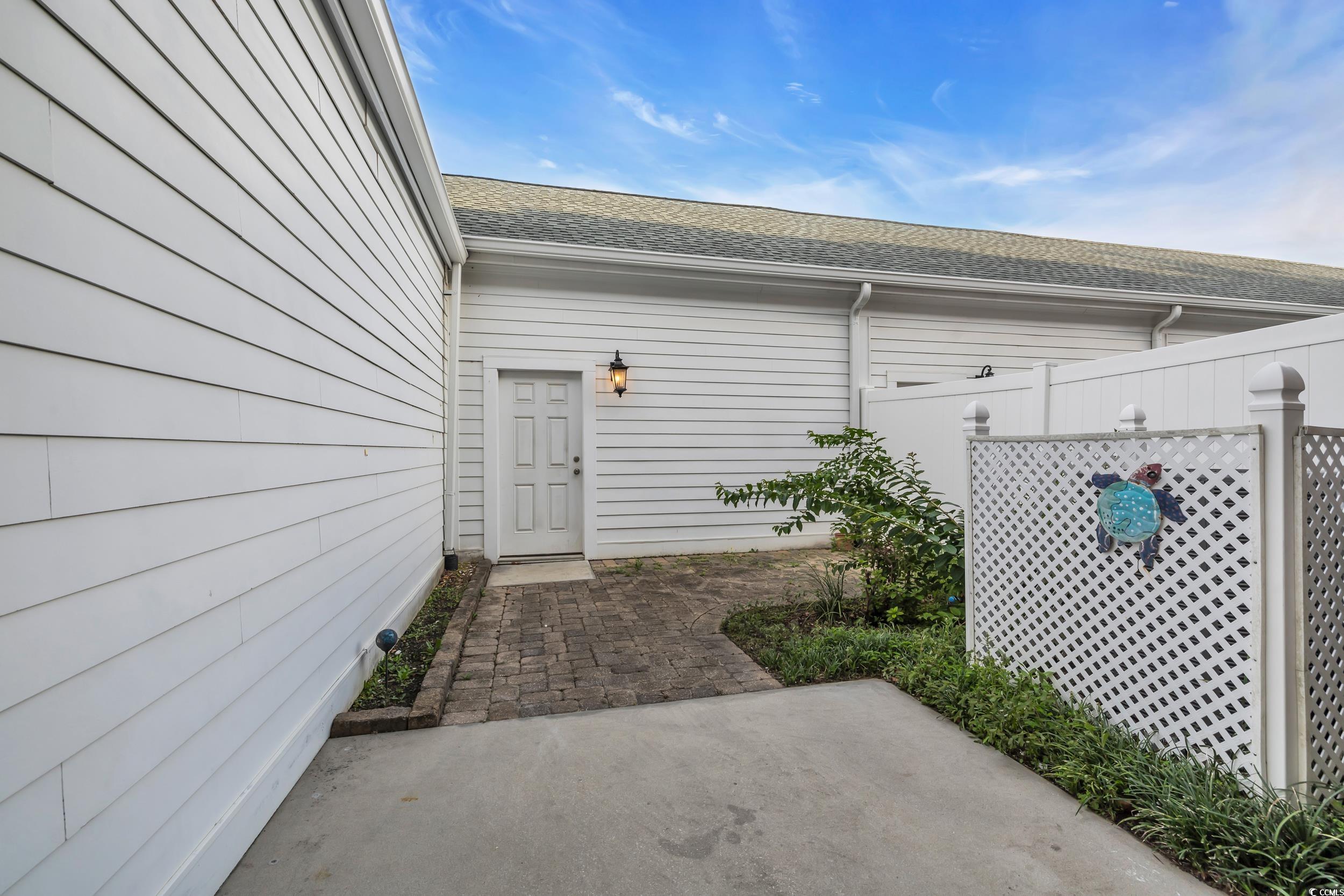 945 Rosencrans Lane, Unit B Myrtle Beach, SC 29577 - Photo 24 of 32 Doorway to property with a patio area and roof with shingles
