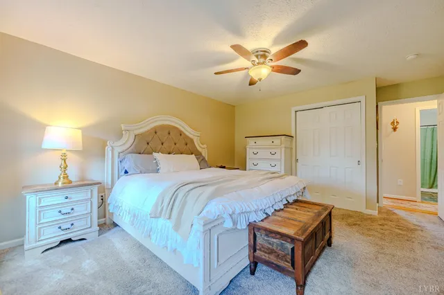 a bedroom with a bed and a lamp on dresser