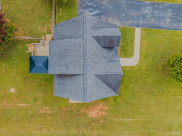 a view of a house with a big yard and large trees