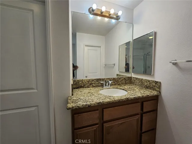 a bathroom with a granite countertop sink a mirror and a vanity