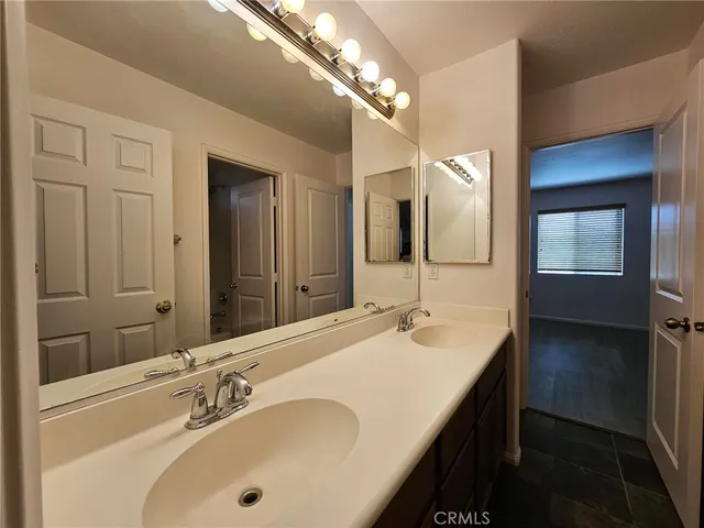 a bathroom with a double vanity sink and a mirror