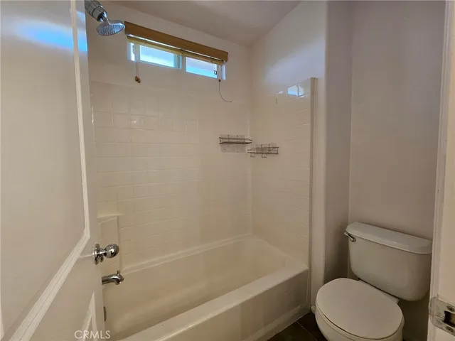 a white toilet sitting next to a bath tub
