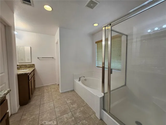 a spacious bathroom with a tub shower and sink