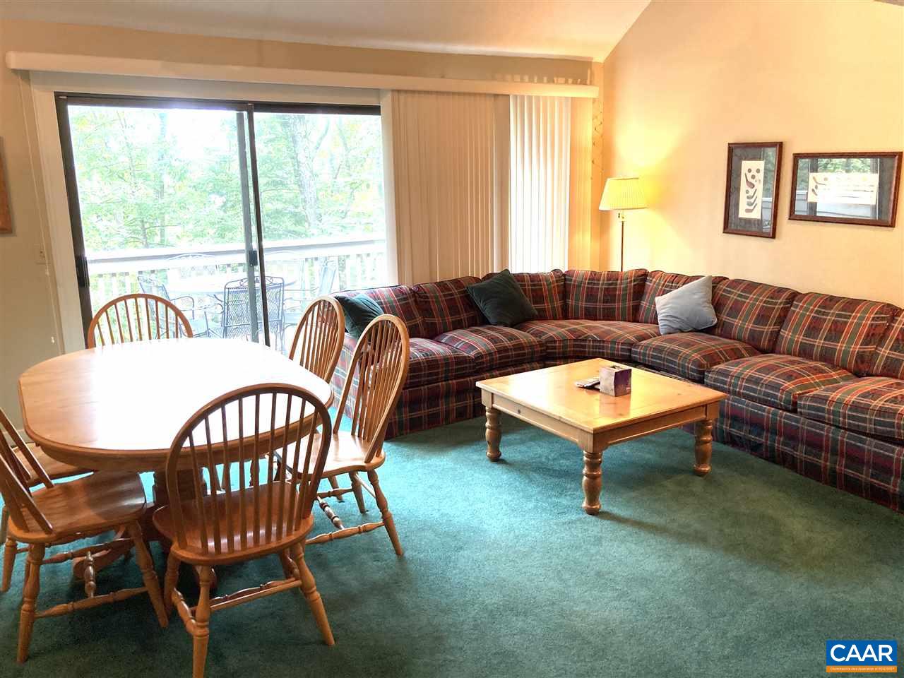 a living room with furniture a table and a large window