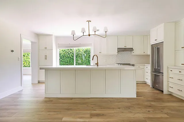 a kitchen with white cabinets and stainless steel appliances