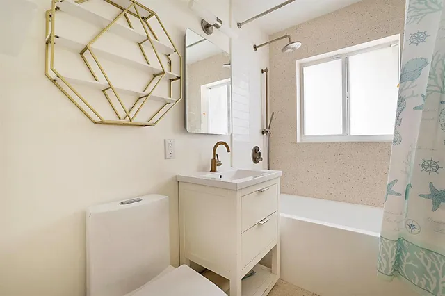 a view of empty room with wooden floor and window