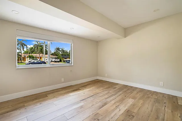 a view of an empty room with wooden floor and closet